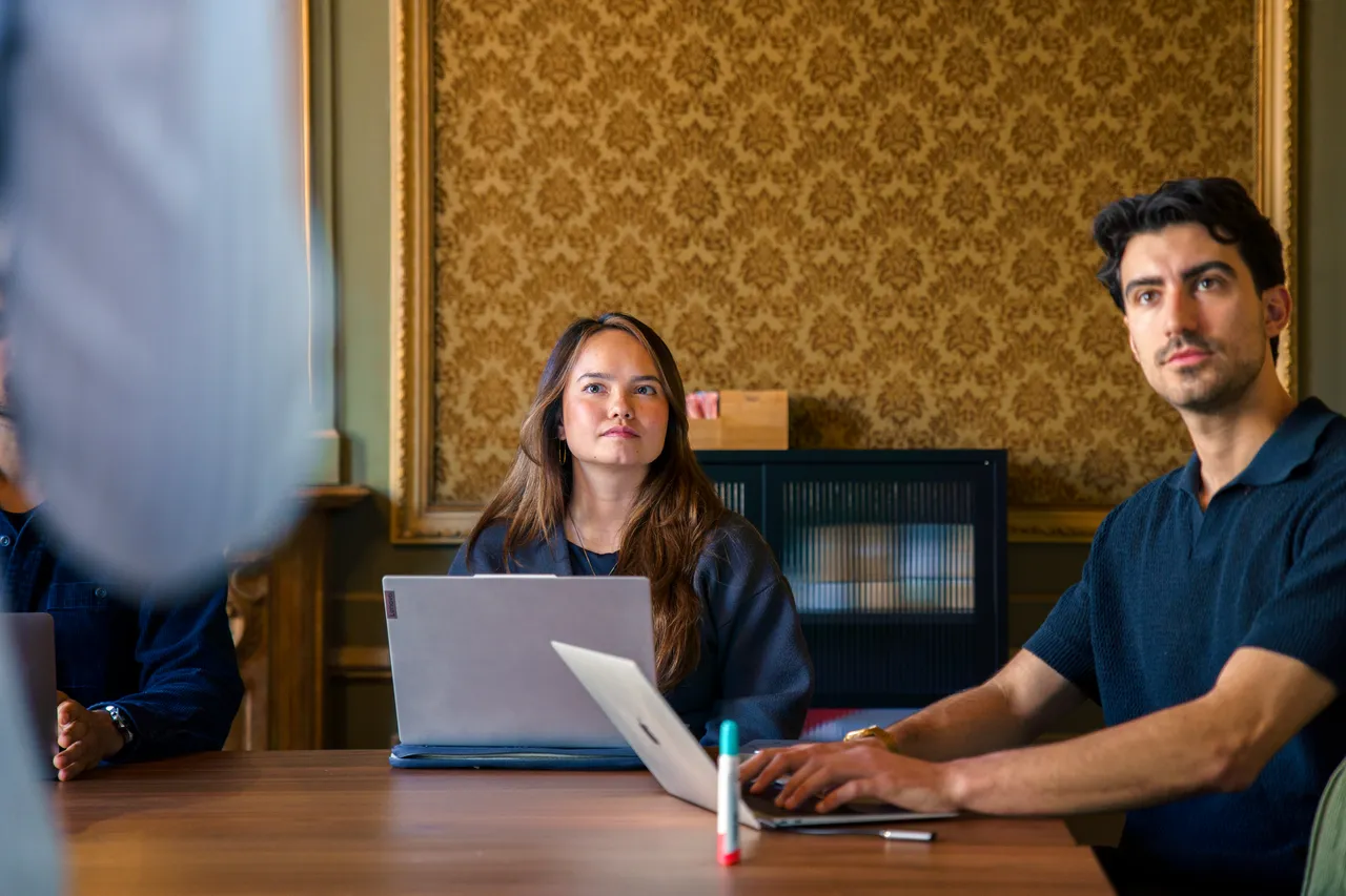 Teamleden van Copilot Cursus volgen aandachtig een sessie aan tafel